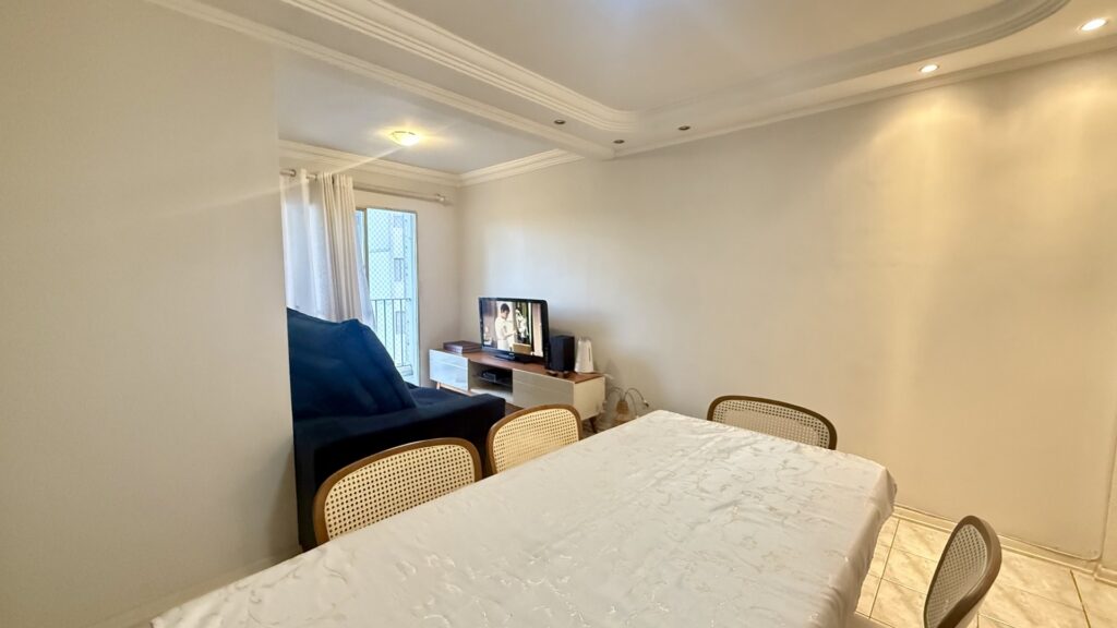 Ambiente de jantar com mesa de seis lugares e iluminação embutida