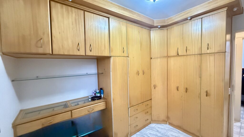 Quarto com armários de madeira clara até o teto