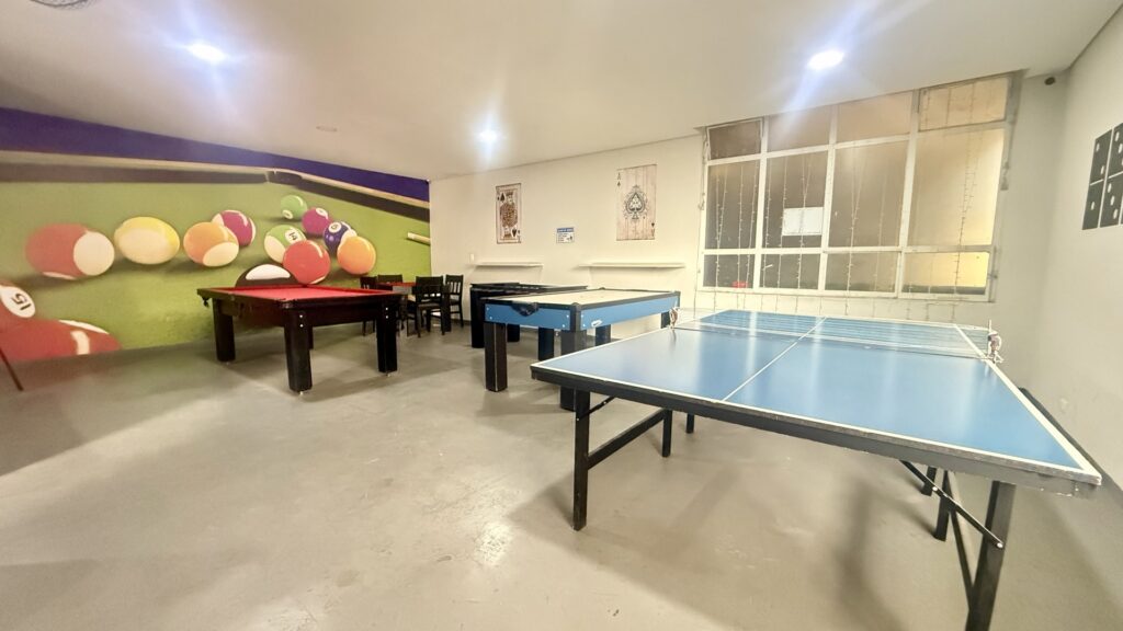 Salão de jogos com sinuca, tênis de mesa e pebolim